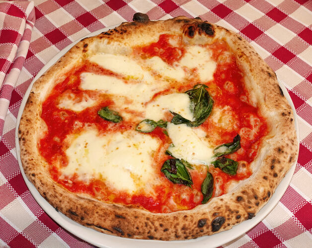 Close up of a neapolitan pizza featuring melted buffalo mozz