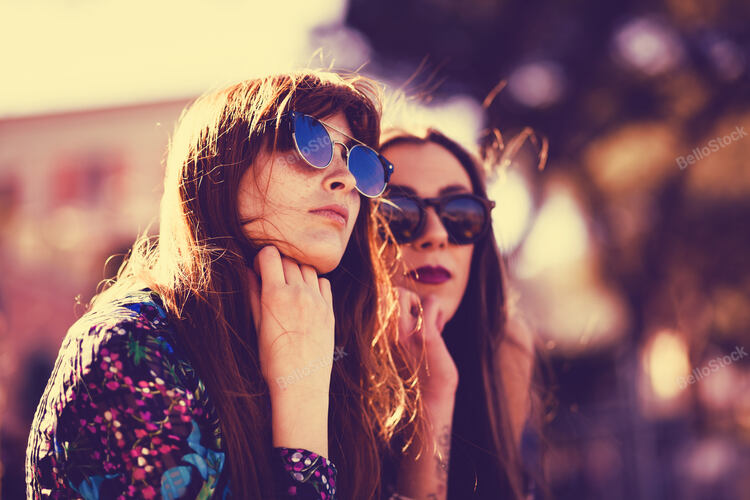 Close up portrait of two friends spending free time at sunse