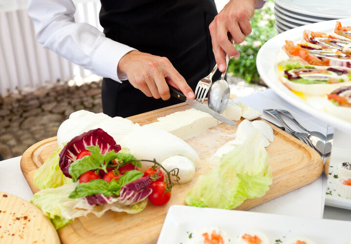 Sliced of mozzarella from the waiter during a wedding recept