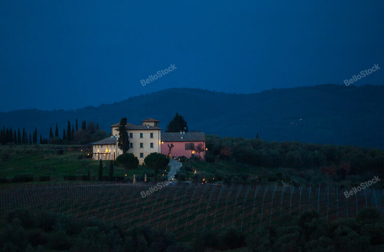 Tuscan landscape and country road with cypress, trees and an