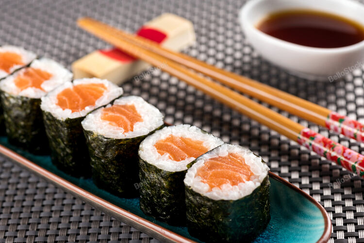 Salmon Hosomaki sushi served in restaurant, with chopsticks 
