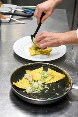 High angle of anonymous man putting delicious ravioli pasta 