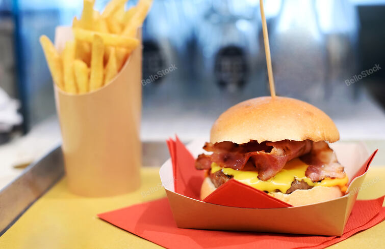 Serving a crunchy hamburger with melted cheese and bacon on 