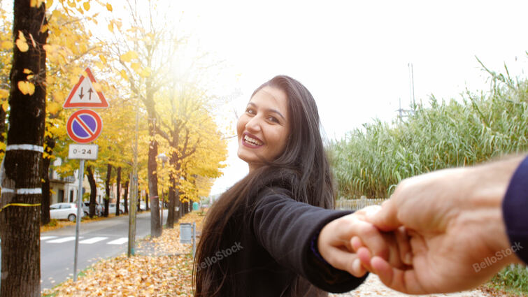 Young woman runs holding her boyfriend by the hand. Autumn s