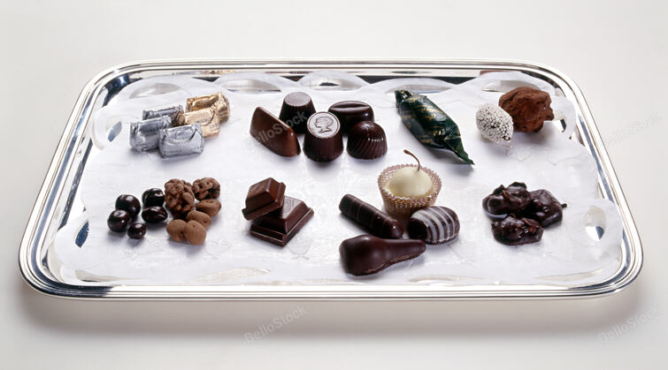 Handmade luxury chocolates displayed on a tray with a variety of shapes, types o