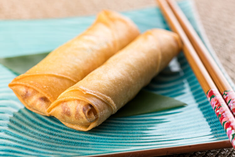 From above of delicious spring rolls served on blue ceramic 
