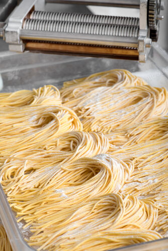 Bundles of freshly made Italian spaghetti pasta on a white p