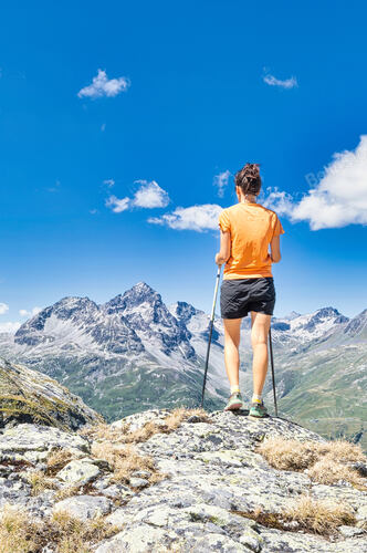 A young woman observes the view over the alps