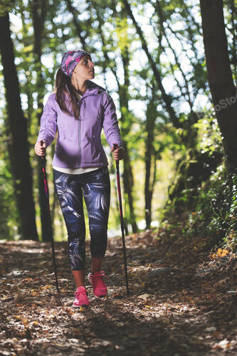Beautiful girl during a hike with Nordic walking practice in