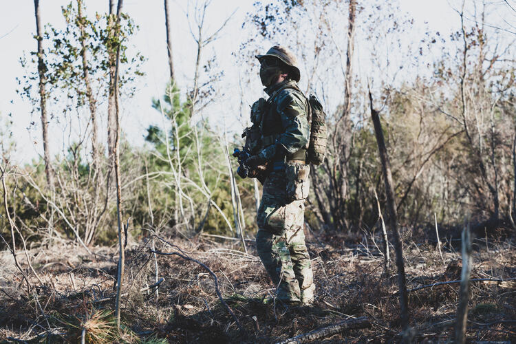 Airsoft military game player in camouflage uniform with arme