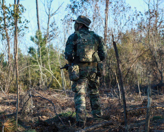Airsoft player wearing camouflage uniform and carrying equip