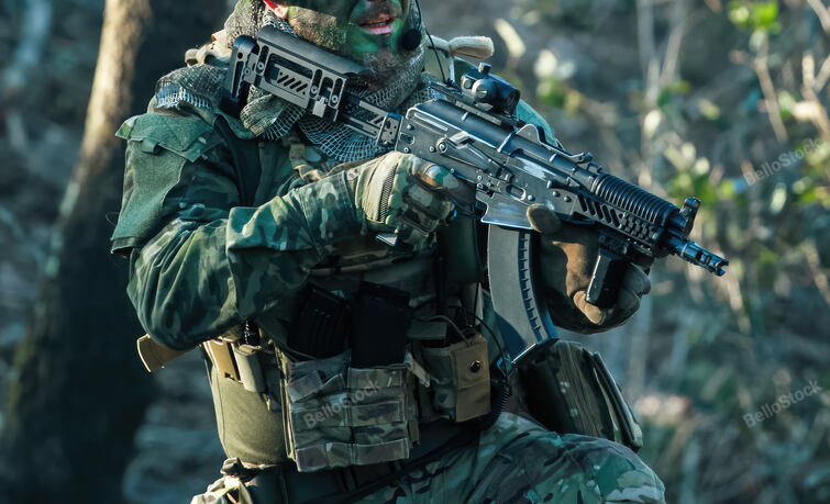 Airsoft player wearing camouflage uniform and holding a rifl