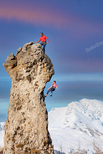 A climber at the top makes his partner go down the rope