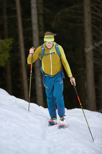 A man mountain skier going uphill on the Italian pre-Alps