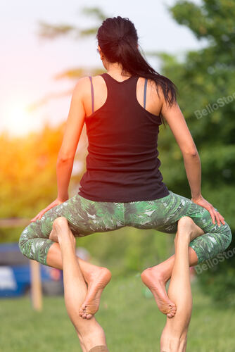 Acro yoga in the park towards the sun
