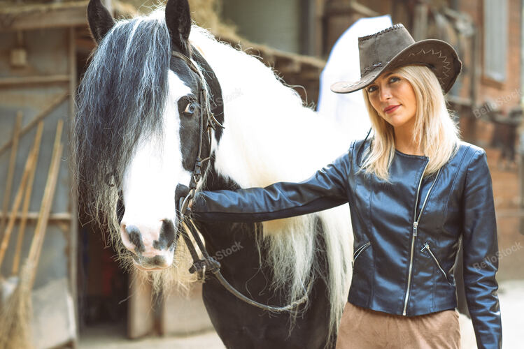 Beautiful country style blond woman with black and white hor
