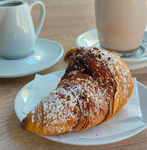 Selective focus of delicious croissant poured with chocolate