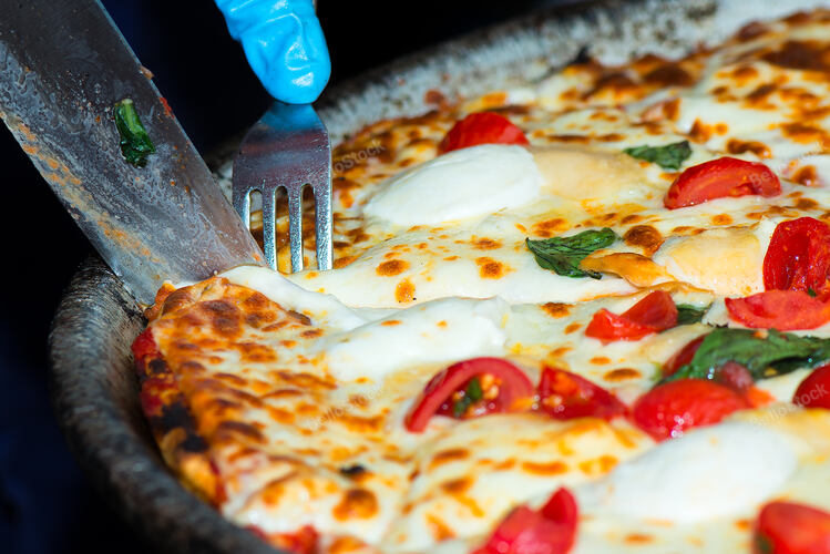 Cut the slice of pizza in a market in the street