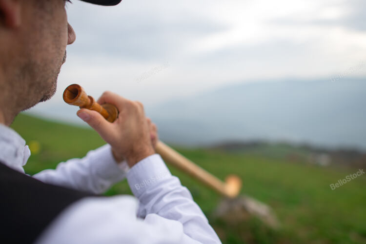 Detail of an Alpine horn player. On the Alps.